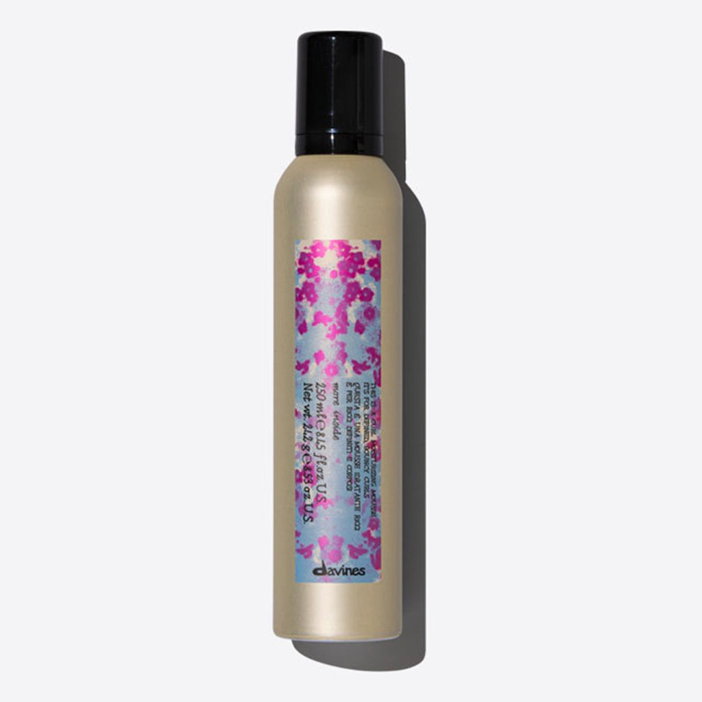 Gold bottle of moisturizing & curling mousse with pink and purple label
